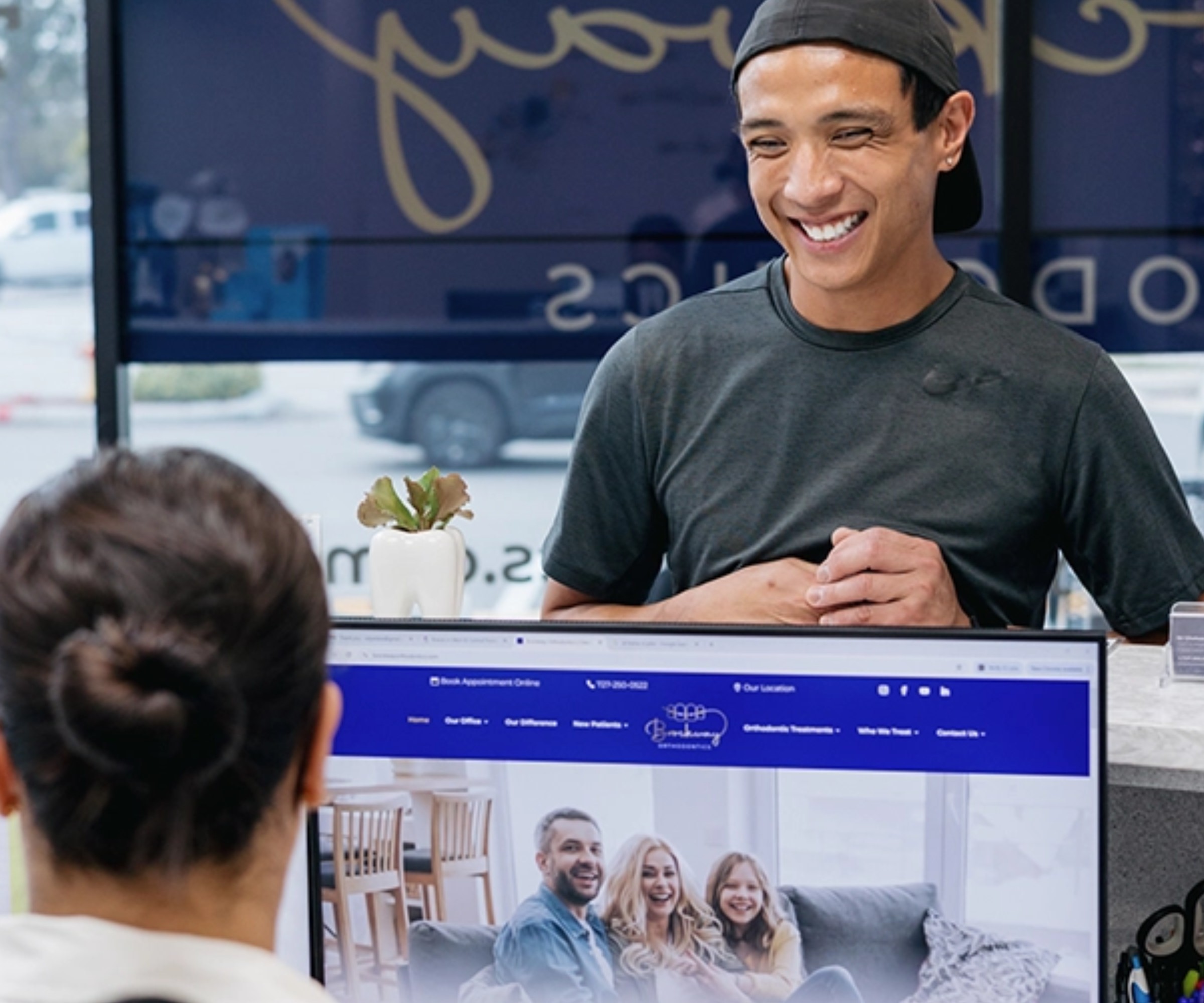 Focus on Patient Education patient smiling while talking to team member at the front desk